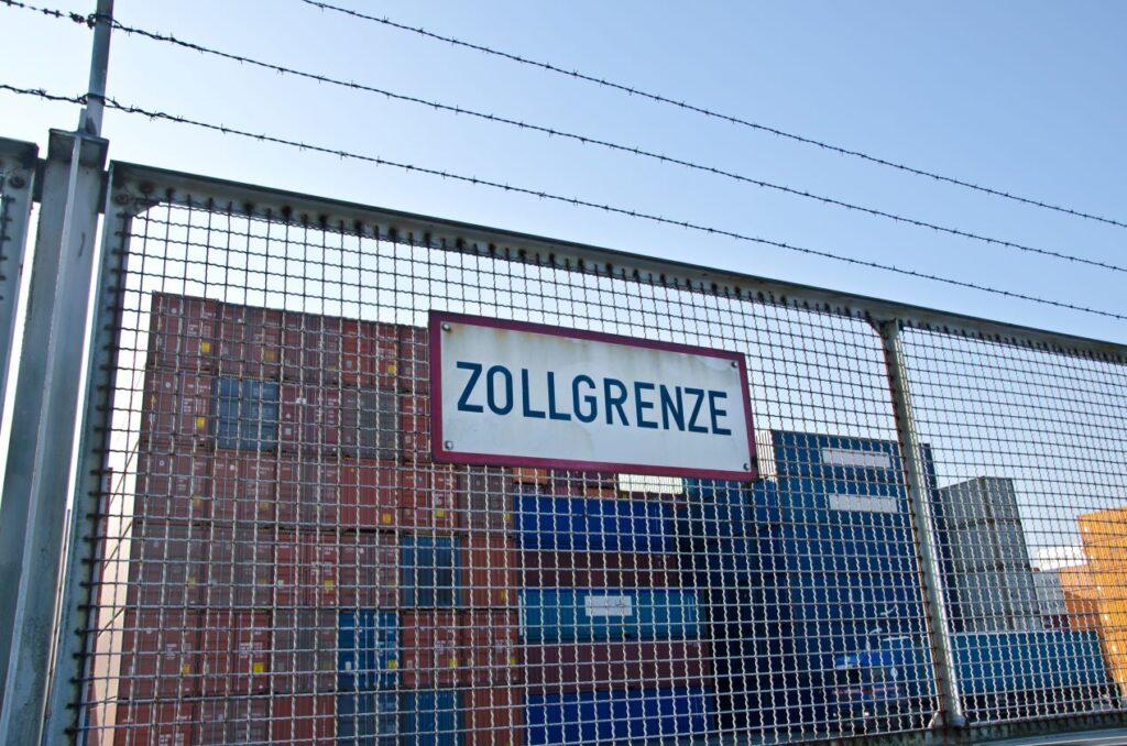 Zollgrenze mit Containern im Hintergrund – wichtig für den Import von Solarmodulen aus dem Solar Großhandel.