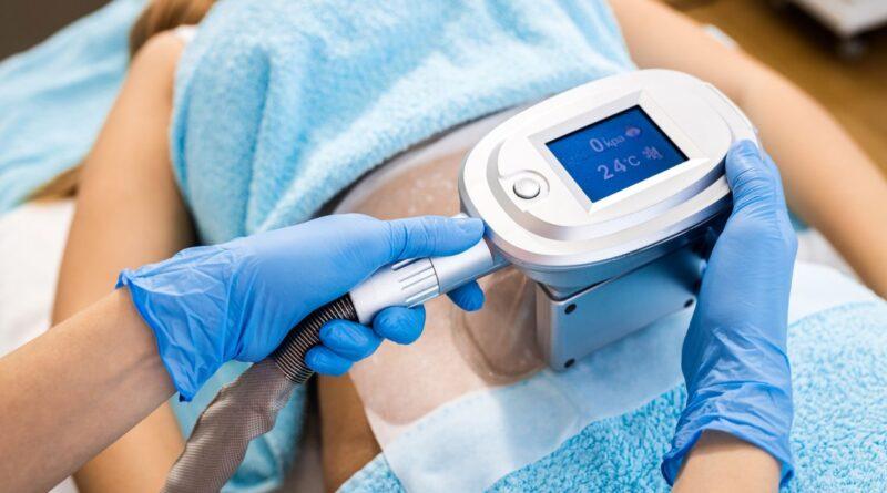 Detailaufnahme einer Kryolipolyse Behandlung am Bauch mit medizinischem Geraet bei einer Patientin in liegender Position