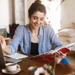 Studentin schreibt mit Laptop und Heften | Ghostwriter Masterarbeit